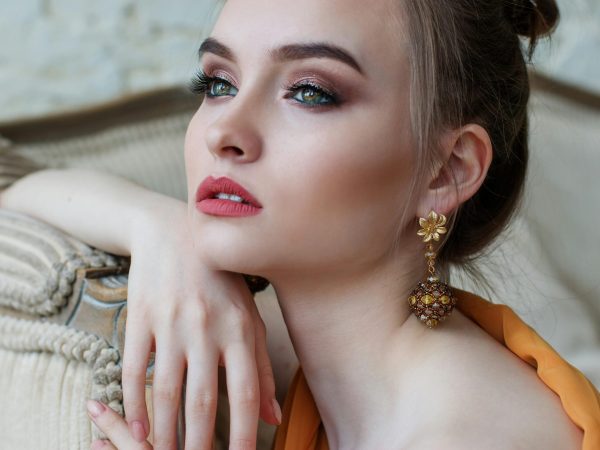 Stunning close-up portrait of a woman with elegant makeup and jewelry, epitomizing modern fashion and beauty.